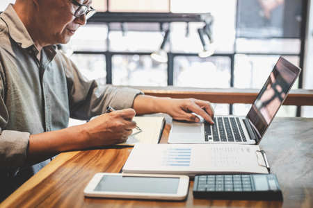 Senior professional businessman in casual wear working using laptop in cafe with business working connecting to wireless via computer.の写真素材