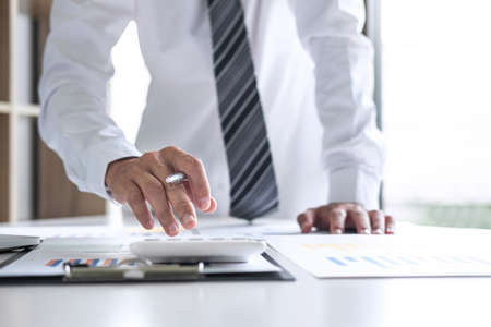Businessman accountant working analyzing and calculating expense annual financial report balance sheet statement, doing finance making notes on report, Financing Accounting Banking Concept.の写真素材