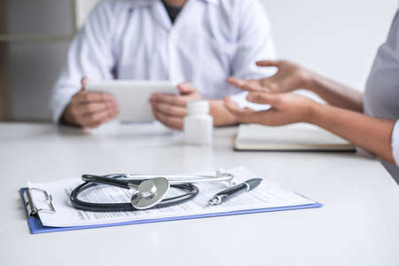 Doctor consulting with patient and checking sickness condition while presenting results diagnosis symptom examining about the problem of illness and recommend treatment method, Healthcare and medical.の写真素材