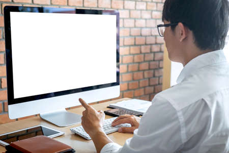 Image of Young man working in front of the computer laptop looking at screen with a clean white...