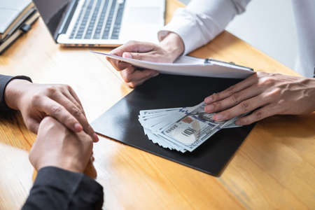 Dishonest cheating in business illegal money, Businessman giving bribe money in business people to give success the deal contract of investment, Bribery and corruption concept.の写真素材