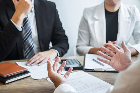Employer or recruiter holding reading a resume with talking during about his profile of candidate, employer in suit is conducting a job interview, manager resource employment and recruitment concept.の写真素材