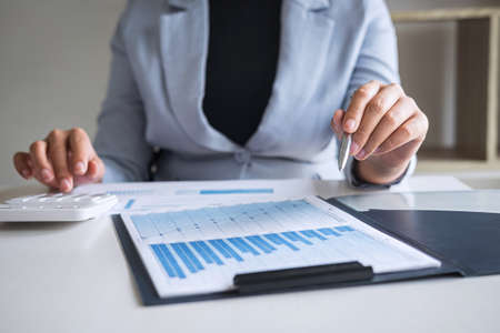 Business woman accountant working audit and calculating expense financial annual financial report balance sheet statement, doing finance making notes on paper checking document.の写真素材