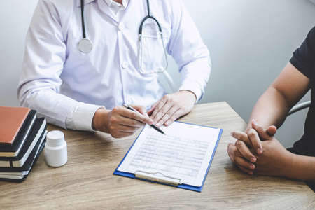 Doctor having conversation with patient while discussing explaining symptoms or counsel diagnosis health and consult treatment of disease, healthcare and assistance concept.の写真素材