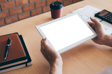 Tablet horizontal screen mockup, Image of Young man working in front of the digital tablet switching on to start his work, looking at screen with a clean screen and blank space for text.の写真素材