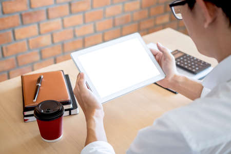 Tablet horizontal screen mockup, Image of Young man working in front of the digital tablet switching on to start his work, looking at screen with a clean screen and blank space for text.の写真素材