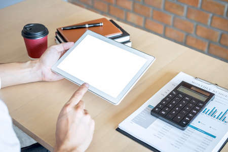 Tablet horizontal screen mockup, Image of Young man working in front of the digital tablet switching on to start his work, looking at screen with a clean screen and blank space for text.の写真素材