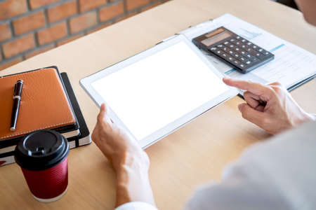 Tablet horizontal screen mockup, Image of Young man working in front of the digital tablet switching on to start his work, looking at screen with a clean screen and blank space for text.の写真素材