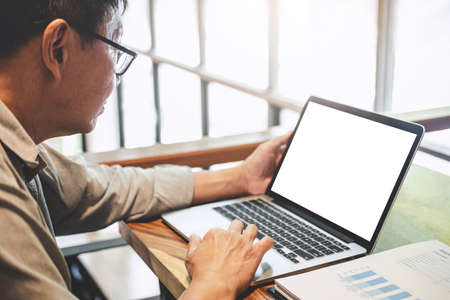 Senior professional businessman in casual wear working using laptop in cafe with business working connecting to wireless via computer, blank screen.の写真素材