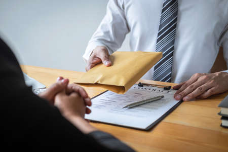 Dishonest cheating in illegal money, Businessman giving bribe money the form of dollar bills to while give success the deal to contract agreement, Bribery and corruption concept.の写真素材