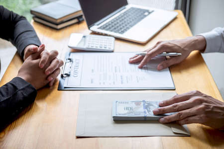 Dishonest cheating in business illegal money, Businessman giving bribe money in business people to give success the deal contract of investment, Bribery and corruption concept.の写真素材