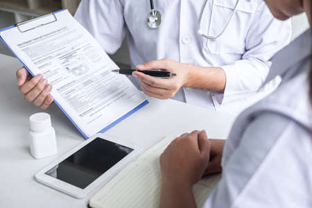 Doctor consulting with patient and checking sickness condition while presenting results diagnosis symptom examining about the problem of illness and recommend treatment method, Healthcare and medical.の写真素材