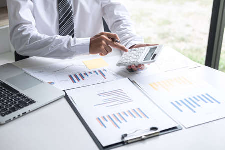 Businessman accountant working analyzing and calculating expense annual financial report balance sheet statement, doing finance making notes on report, Financing Accounting Banking Concept.の写真素材