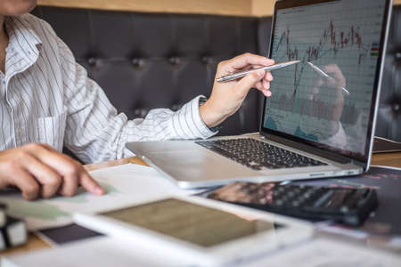 Stock exchange market concept, Business investor trading or stock brokers having a planning and analyzing with display screen and pointing on the data presented and deal on a stock exchange.の写真素材