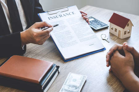 Estate agent broker reach contract form to client signing agreement contract real estate with approved mortgage application form, buying or concerning mortgage loan offer for and house insurance.の写真素材
