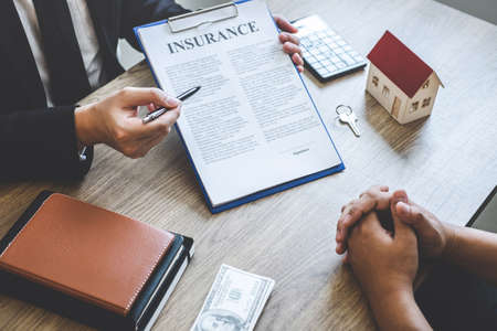 Estate agent broker reach contract form to client signing agreement contract real estate with approved mortgage application form, buying or concerning mortgage loan offer for and house insurance.の写真素材
