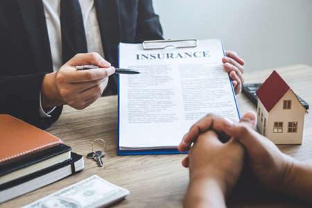 Estate agent broker reach contract form to client signing agreement contract real estate with approved mortgage application form, buying or concerning mortgage loan offer for and house insurance.の写真素材