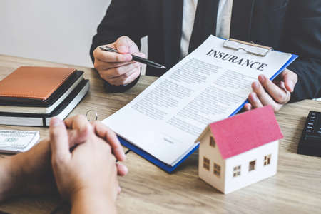Estate agent broker reach contract form to client signing agreement contract real estate with approved mortgage application form, buying or concerning mortgage loan offer for and house insurance.の写真素材