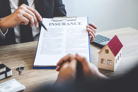 Estate agent broker reach contract form to client signing agreement contract real estate with approved mortgage application form, buying or concerning mortgage loan offer for and house insurance.の写真素材