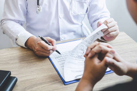 Professional doctor in white uniform gown coat and patient discussing consults to treatment of symptom disease and making prescriptions.の写真素材