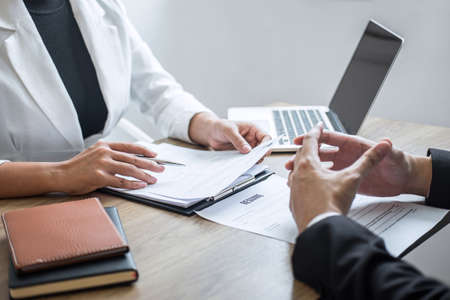 Employer or recruiter holding reading a resume with talking during about his profile of candidate, employer in suit is conducting a job interview, manager resource employment and recruitment concept.の写真素材