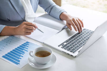 Business woman accountant financier working audit and calculating expense financial annual report balance sheet statement, doing finance checking document and making notes on report paper.の写真素材