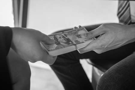 Dishonest cheating in business illegal money, Businessman receive bribe money under table to business people to give success the deal contract of investment, Bribery and corruption concept.の写真素材
