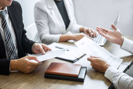 Employer or committee holding reading a resume with talking during about his profile of candidate, employer in suit is conducting a job interview, manager resource employment and recruitment concept.の写真素材