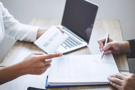 Stressed businessman receive fired letter from employer will be signing approve contract agreement, changing and resigning from work concept.の写真素材