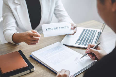 Stressed businessman receive fired letter from employer will be signing approve contract agreement, changing and resigning from work concept.の写真素材
