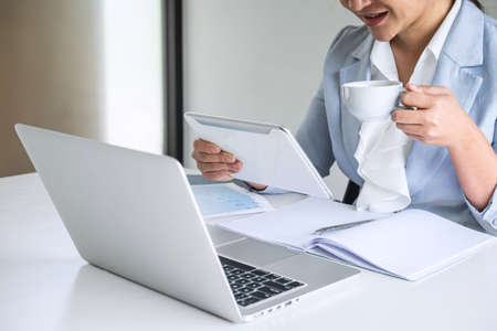 Business woman accountant financier working audit and calculating expense financial annual report balance sheet statement, doing finance checking document and making notes on report paper.の写真素材