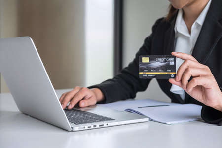 Business woman consumer holding credit card and typing on laptop for online shopping and payment make a purchase on the Internet, Online payment, networking and buy product technology.の写真素材