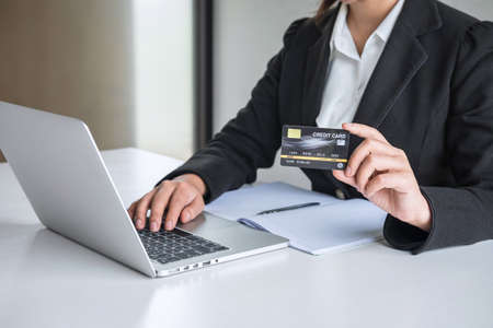 Business woman consumer holding credit card and typing on laptop for online shopping and payment make a purchase on the Internet, Online payment, networking and buy product technology.の写真素材