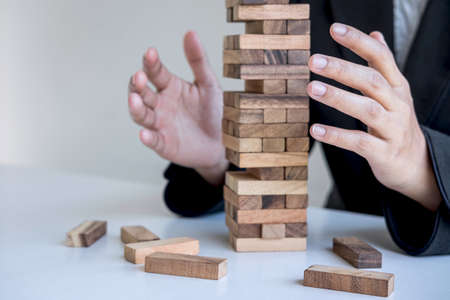 Alternative Risk and Strategy in business, Business woman's hands protect balance wooden stack with hand control risk shape hierarchy on growing to lay the foundation and development to successful.の写真素材