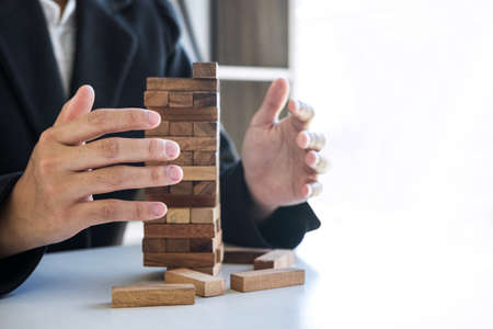 Alternative Risk and Strategy in business, Business woman's hands protect balance wooden stack with hand control risk shape hierarchy on growing to lay the foundation and development to successful.の写真素材