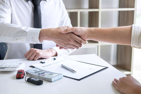 Finishing up of conversation, Realtor agent manager shaking hands with woman client after signing rental form contract agreement, renting considering vehicle car insurance.の写真素材