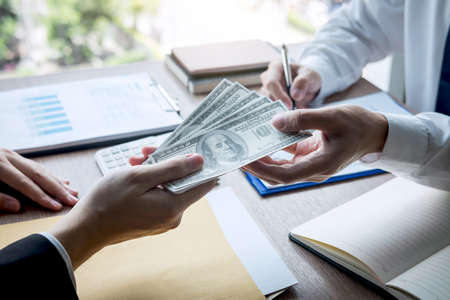 Dishonest cheating in business illegal money, Businessman giving bribe money in business people to accept agreement contract of investment deal, Bribery and corruption concept.の写真素材