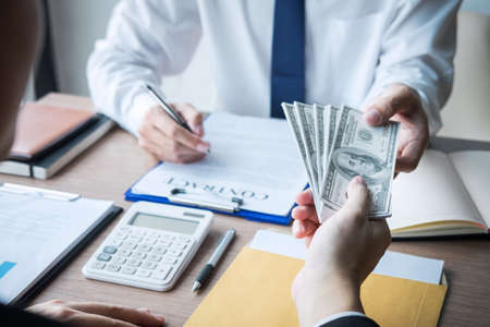 Dishonest cheating in business illegal money, Businessman giving bribe money in business people to accept agreement contract of investment deal, Bribery and corruption concept.の写真素材