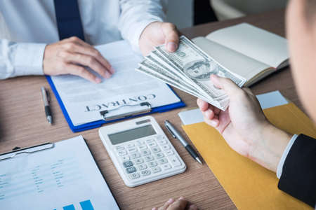 Dishonest cheating in business illegal money, Businessman giving bribe money in business people to accept agreement contract of investment deal, Bribery and corruption concept.の写真素材