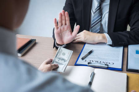 Anti bribery and corruption concept, Business man refusing and don't receive money banknote offer from business people to accept agreement contract of investment deal.の写真素材
