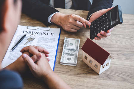Estate agent broker reach contract form and presentation to client signing agreement contract real estate with approved mortgage application form, buying mortgage loan offer for and house insurance.の写真素材