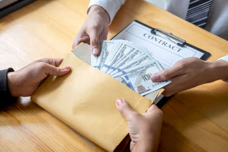 Dishonest cheating in business illegal money, Businessman giving bribe money in envelope to business...