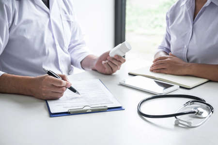 Doctor consulting with patient and checking sickness condition while presenting results diagnosis symptom examining about the problem of illness and recommend treatment method and using medicine.の写真素材