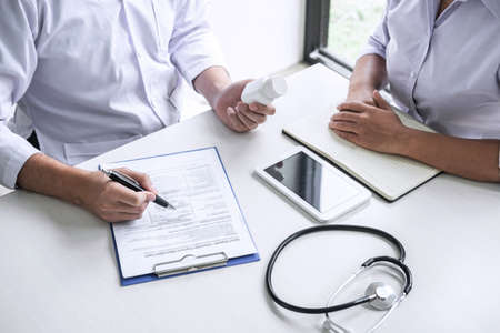 Doctor consulting with patient and checking sickness condition while presenting results diagnosis symptom examining about the problem of illness and recommend treatment method and using medicine.の写真素材