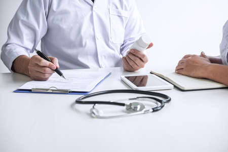 Doctor consulting with patient and checking sickness condition while presenting results diagnosis symptom examining about the problem of illness and recommend treatment method and using medicine.の写真素材