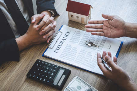 Estate agent broker reach contract form and presentation to client signing agreement contract real estate with approved mortgage application form, buying mortgage loan offer for and house insurance.の写真素材