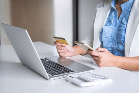 Young woman consumer holding smartphone, credit card and typing on laptop for online shopping and payment make a purchase on the Internet, Online payment, networking and buy product technology.の写真素材