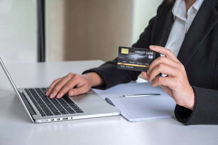 Business woman consumer holding credit card and typing on laptop for online shopping and payment make a purchase on the Internet, Online payment, networking and buy product technology.の写真素材