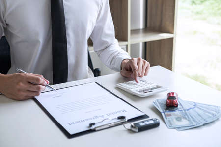Man client calculating insurance premium for decide signing rental contract form of renting a vehicle agreement, car insurance concept.の写真素材