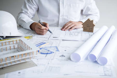 Construction engineering or architect hands working on blueprint inspection in workplace, while checking information drawing and sketching for architecture project working.の写真素材